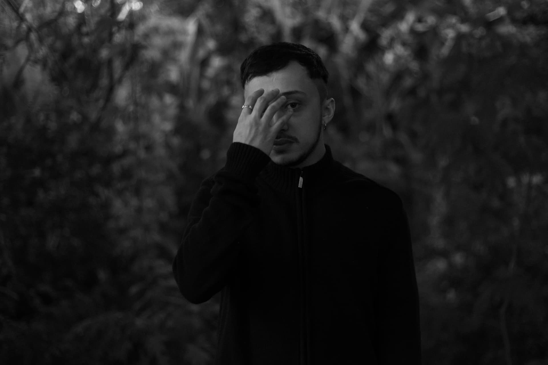 Marcal, black and white press portrait with his hand over his face